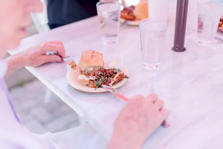 a person sitting at a table eating food