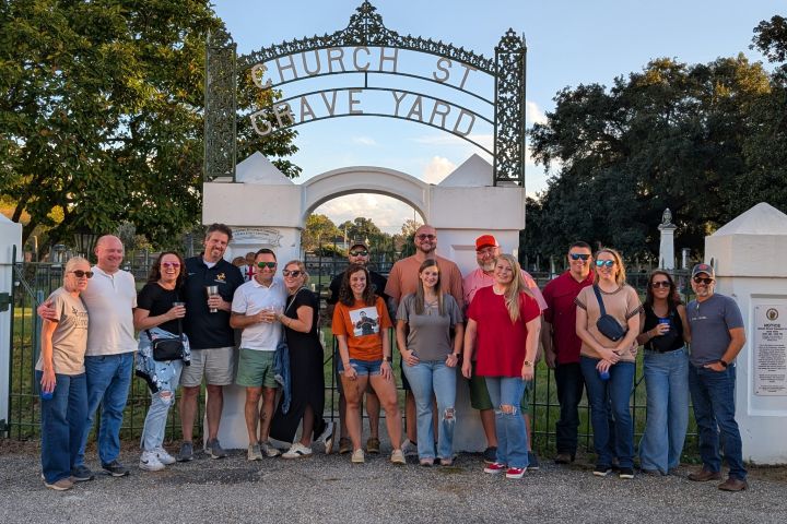 Group of people smiling in front of Church Street graveyard gate.