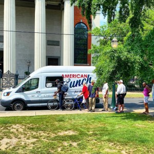 a group of people standing in front of a car