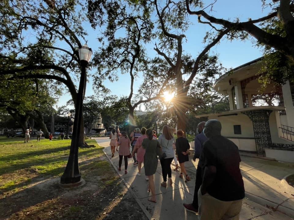 a group of people walking down a street next to a tree