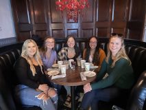 a group of people sitting at a table with wine glasses