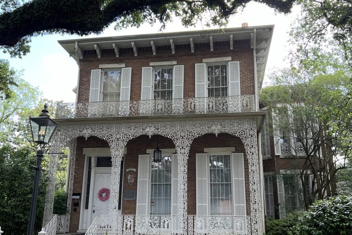 a house with a fence in front of a building